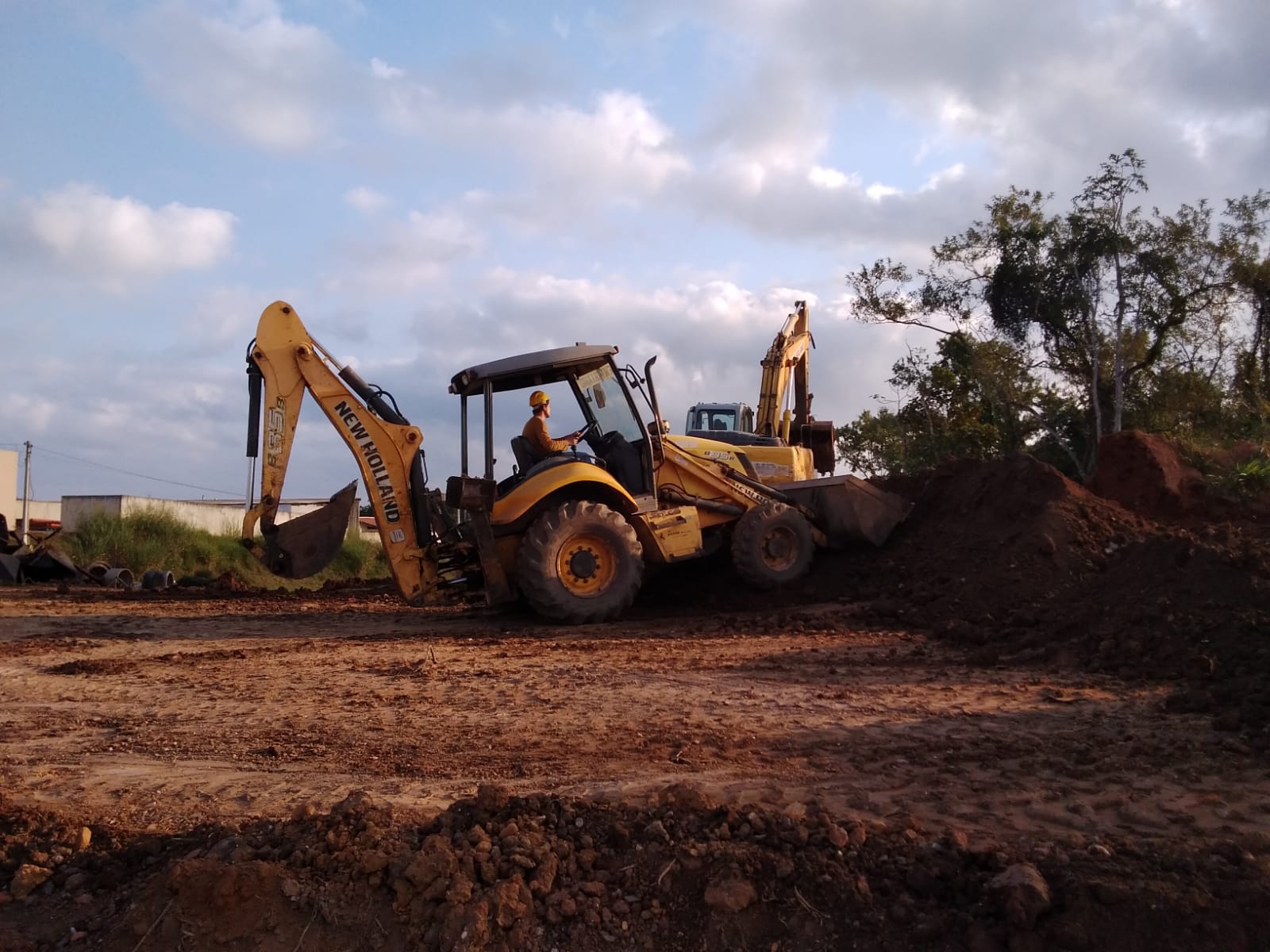 Retroescavadeira e escavadeira em operação