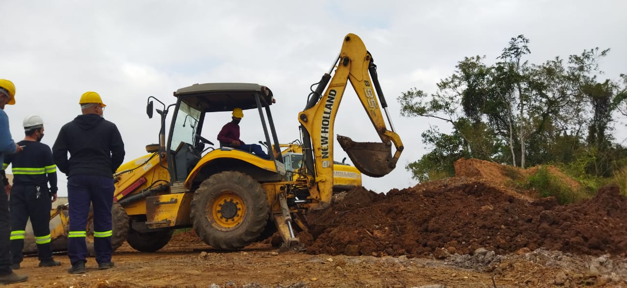 Aluno operando retroescavadeira New Holland
