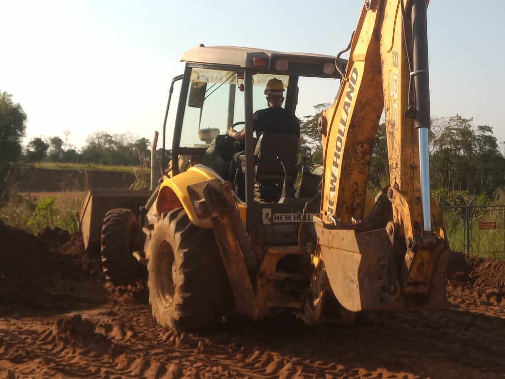 Aluno operando retroescavadeira entardecer