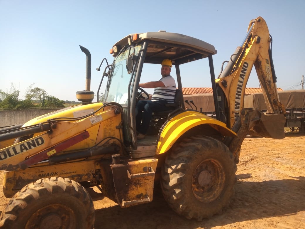 Aluno operando retroescavadeira New Holland