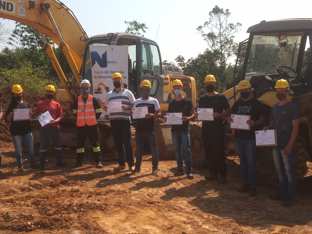 Turma formada em frente às máquinas